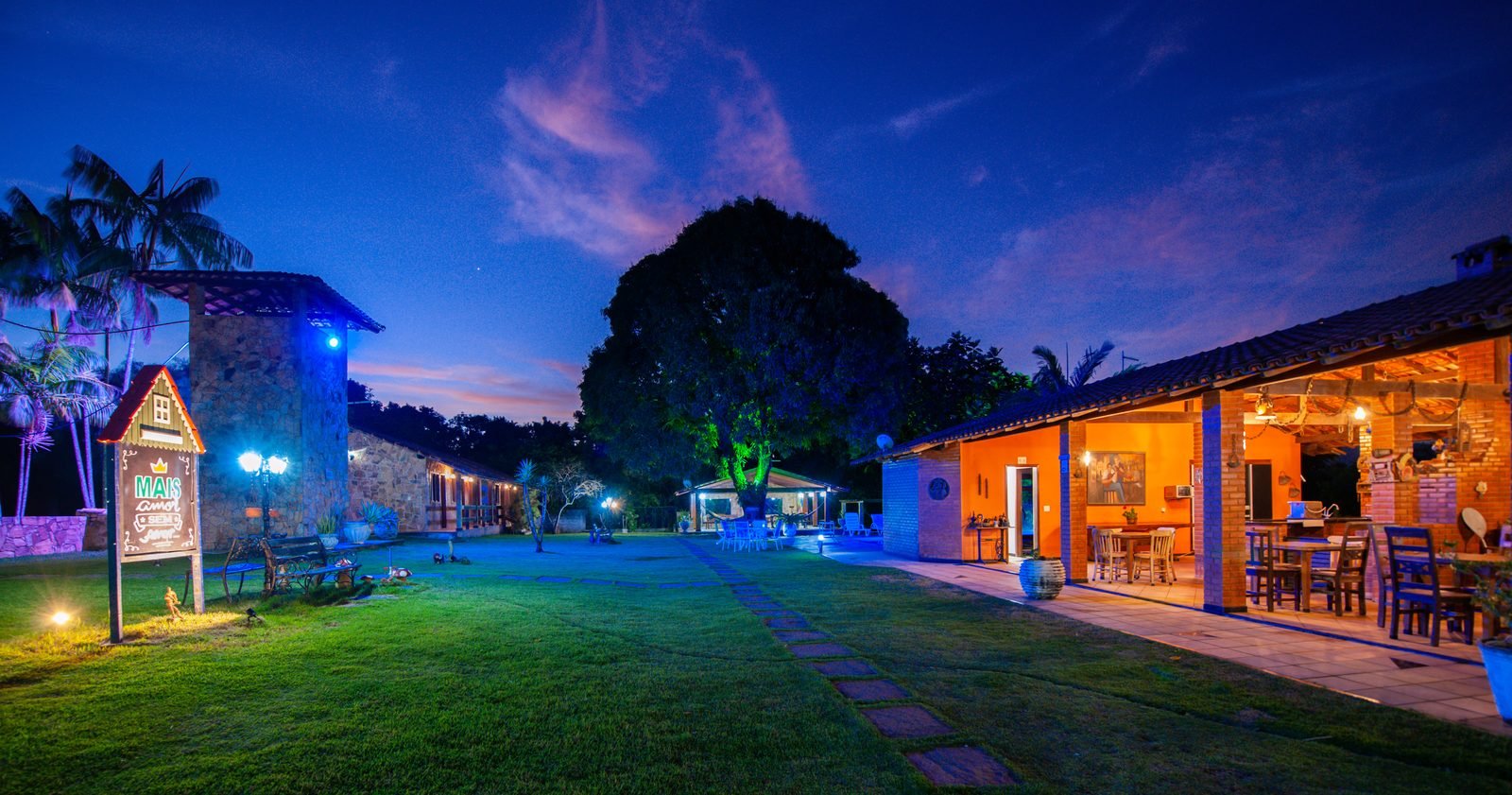 Restaurante e gramado da pousada ao entardecer
